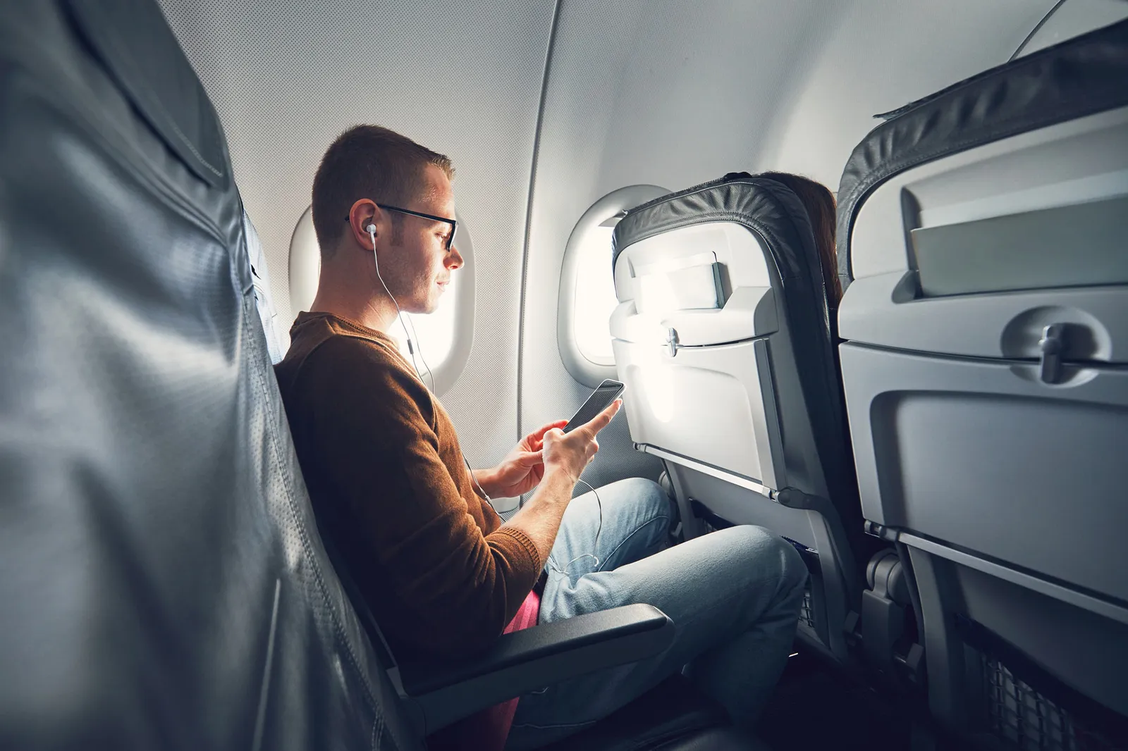 Un homme regarde votre téléphone portable dans un avion