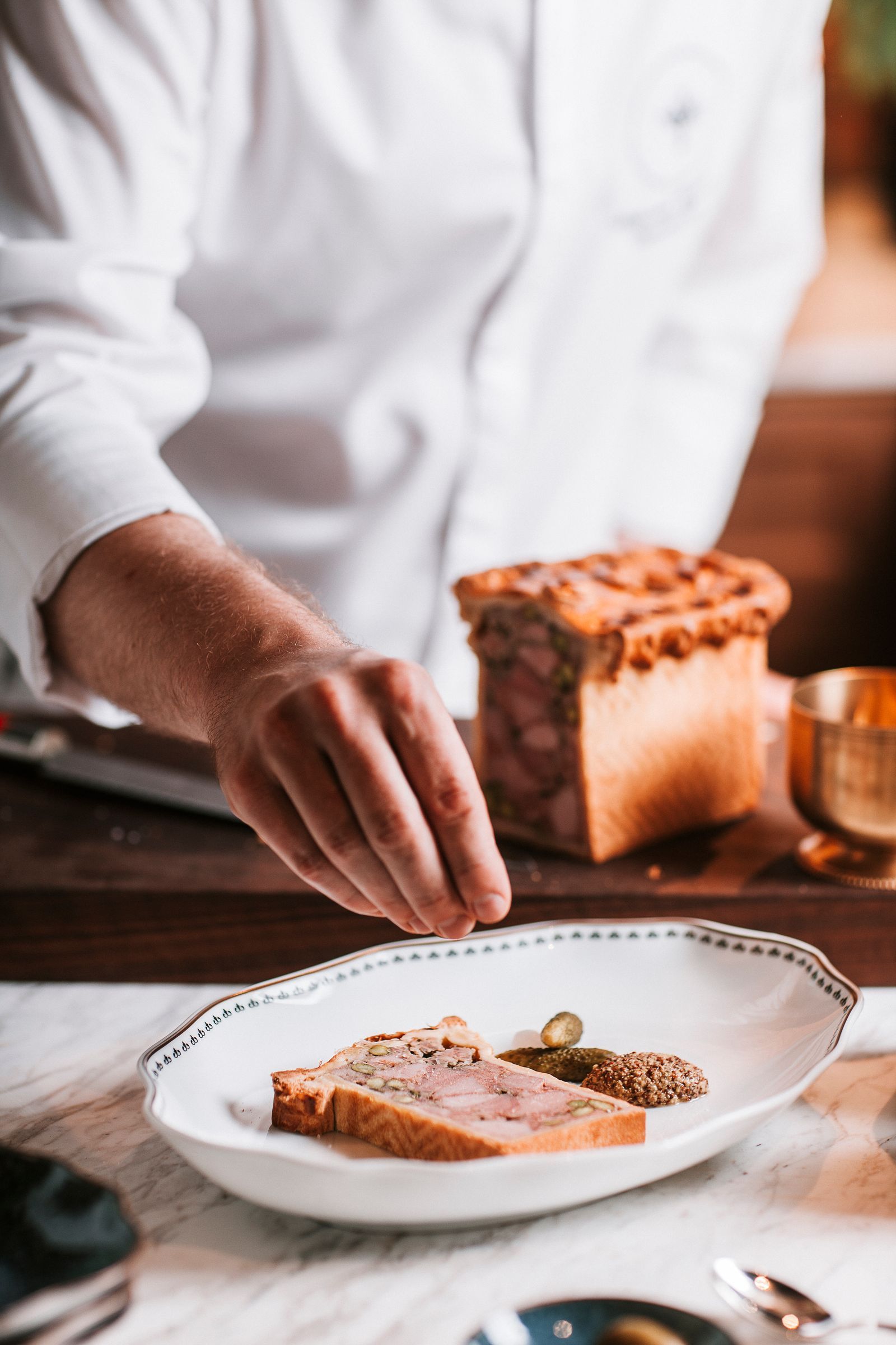 Le chef prépare un plat de pât en croûte dans la brasserie du Rosewood Vienna.
